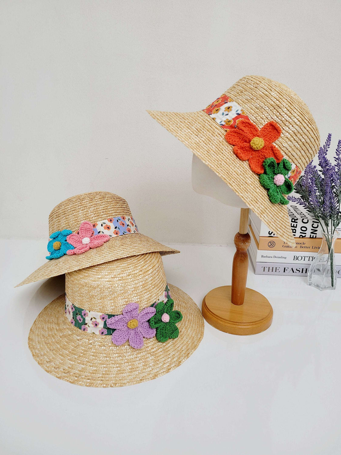 daisy straw bucket hat: Three straw hats with colorful floral bands, each adorned with unique crochet flower accents. Perfect summer accessory.