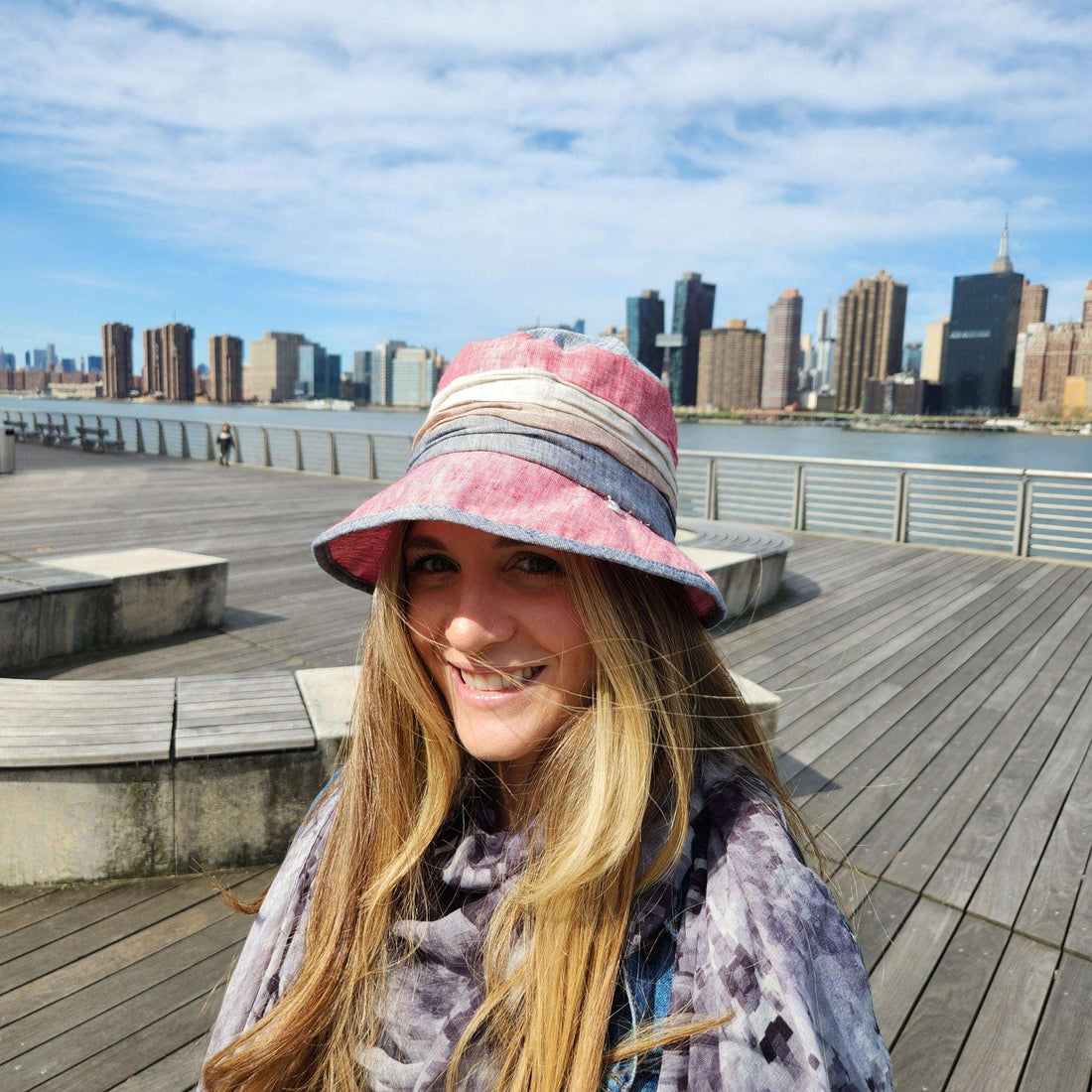 Woman smiles wearing a lic summer breeze bucket hat, a stylish sun protection accessory. The hat has a colorful design, perfect for summer fashion.
