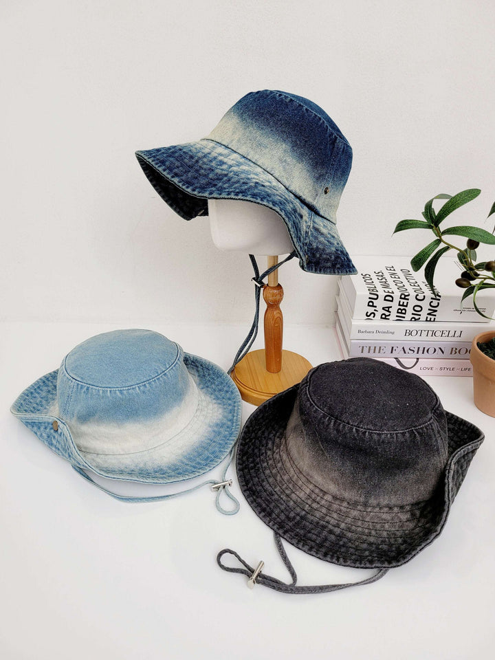 Three cotton denim hat in blue, light blue and gray shades. Each hat has a chin strap, displayed on a white surface.
