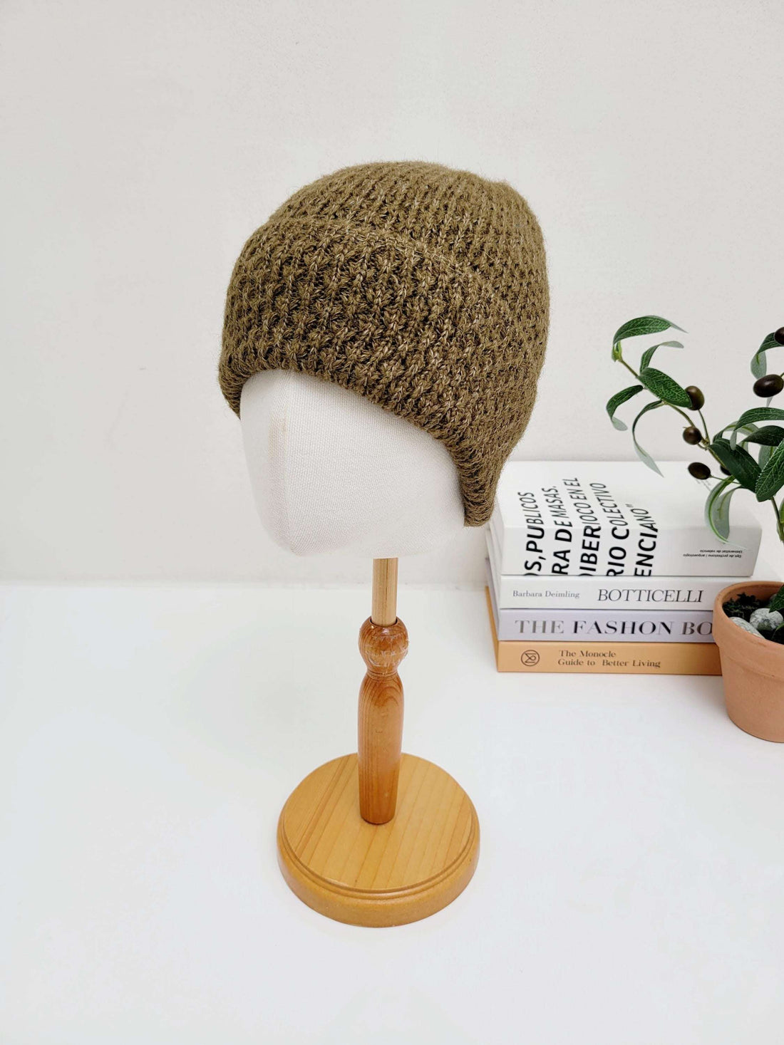Brown knitted TAYLOR beanie on a mannequin head, showcasing its textured stitch and warm, earthy tone.