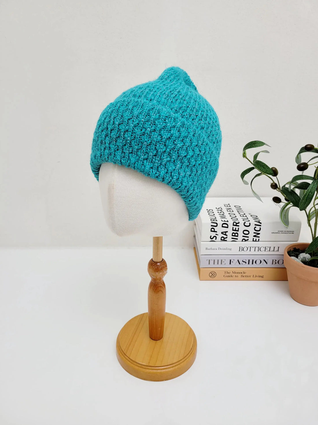 Bright teal knitted beanie hat on a mannequin, showcasing the TAYLOR's textured stitch and snug fit.