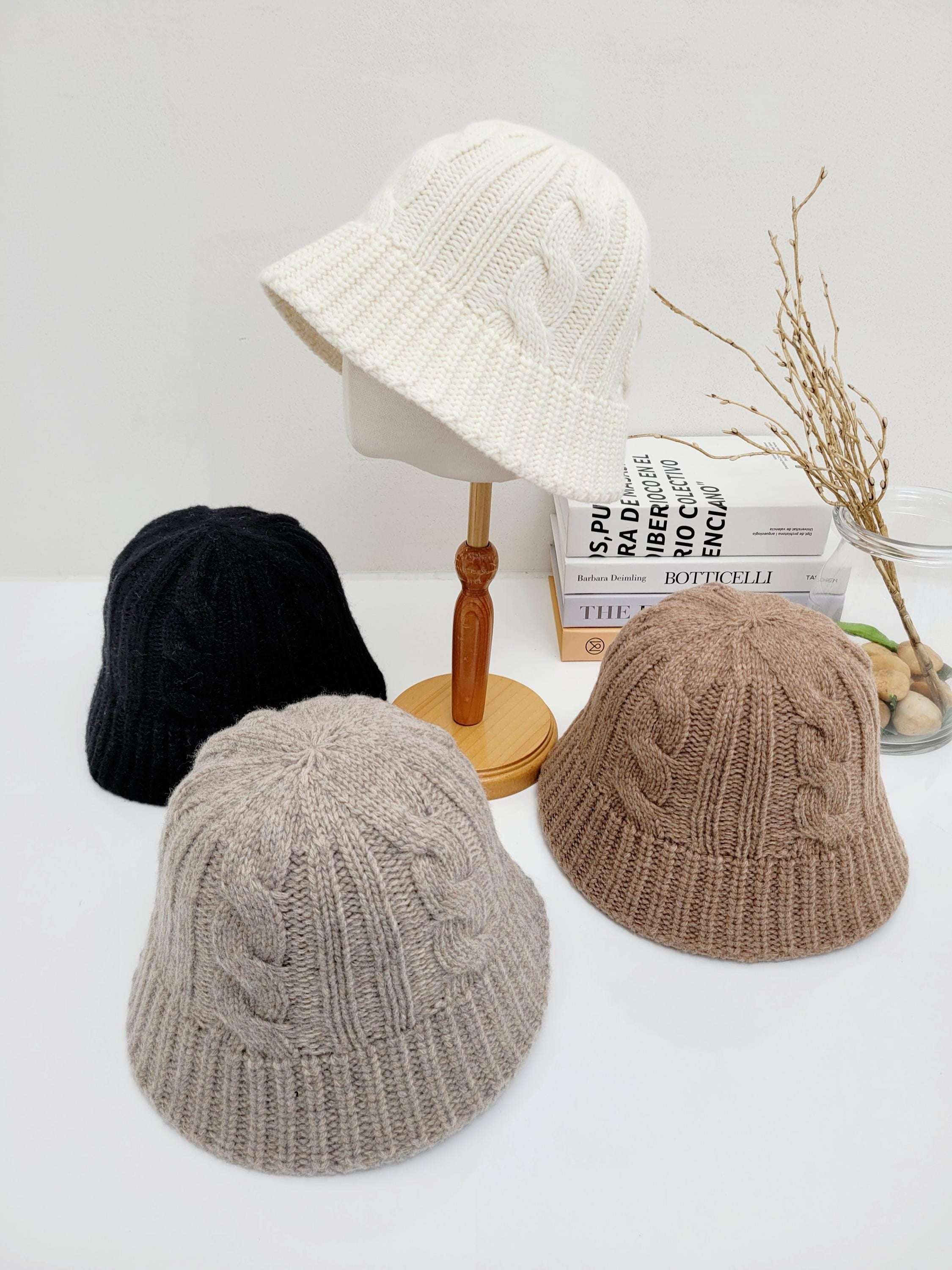 cable knit hat: Four cozy hats in white, black, beige, and brown. Classic cable knit design. Perfect for winter warmth and style.
