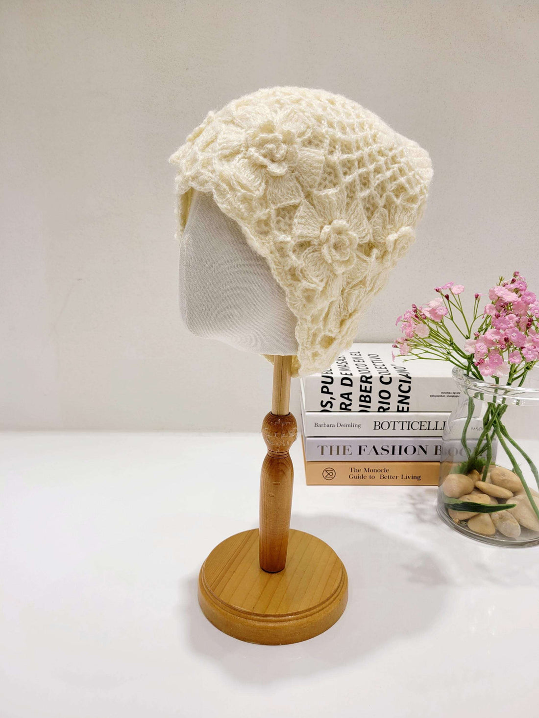 Cream Sharon Beanie: A delicate, flower-patterned crocheted hat on a mannequin head. Perfect for adding a touch of handmade charm.