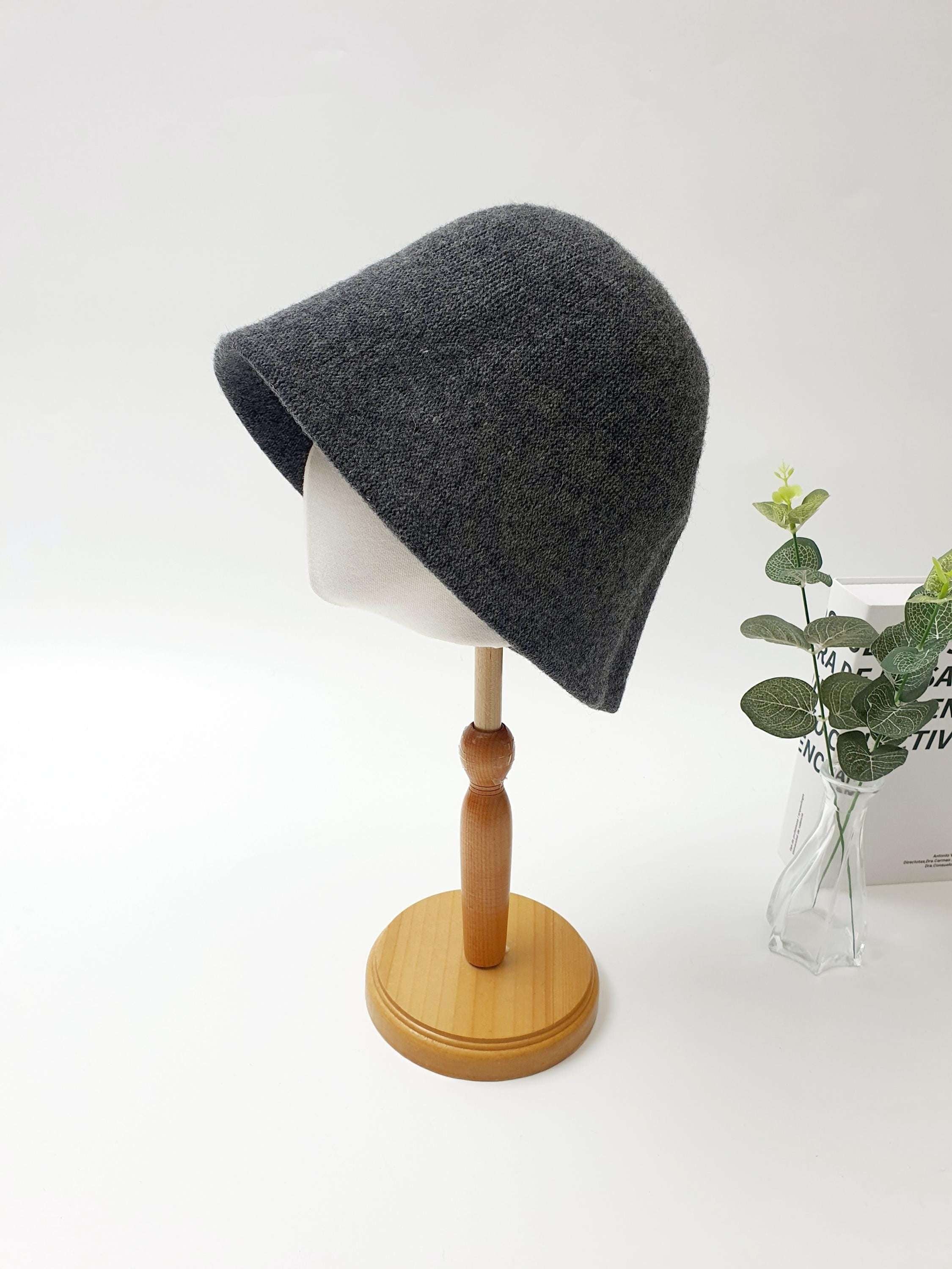 FALL'IN WINTER: Charcoal gray knitted bucket hat on a mannequin, showcasing its soft texture and stylish, relaxed fit.