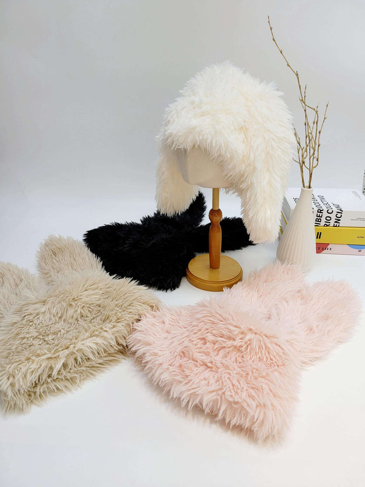 SNOW BUNNY hats: Four fluffy hats in white, black, beige, and pink. Cozy faux fur headwear displayed on a white surface.