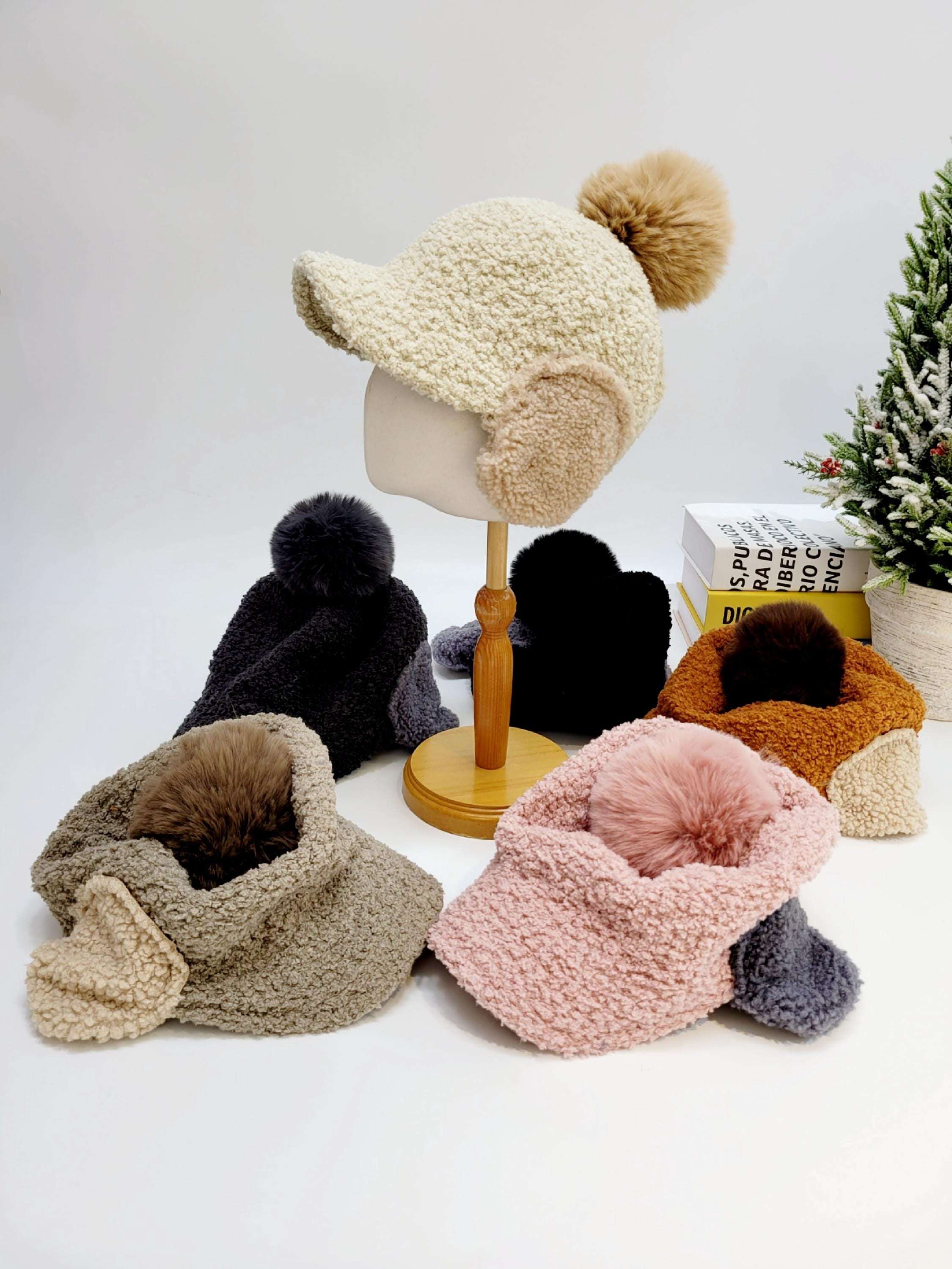 WOOF WOOF fuzzy winter hats: Cream, black, brown, gray, and pink earflap hats with matching pom-poms.