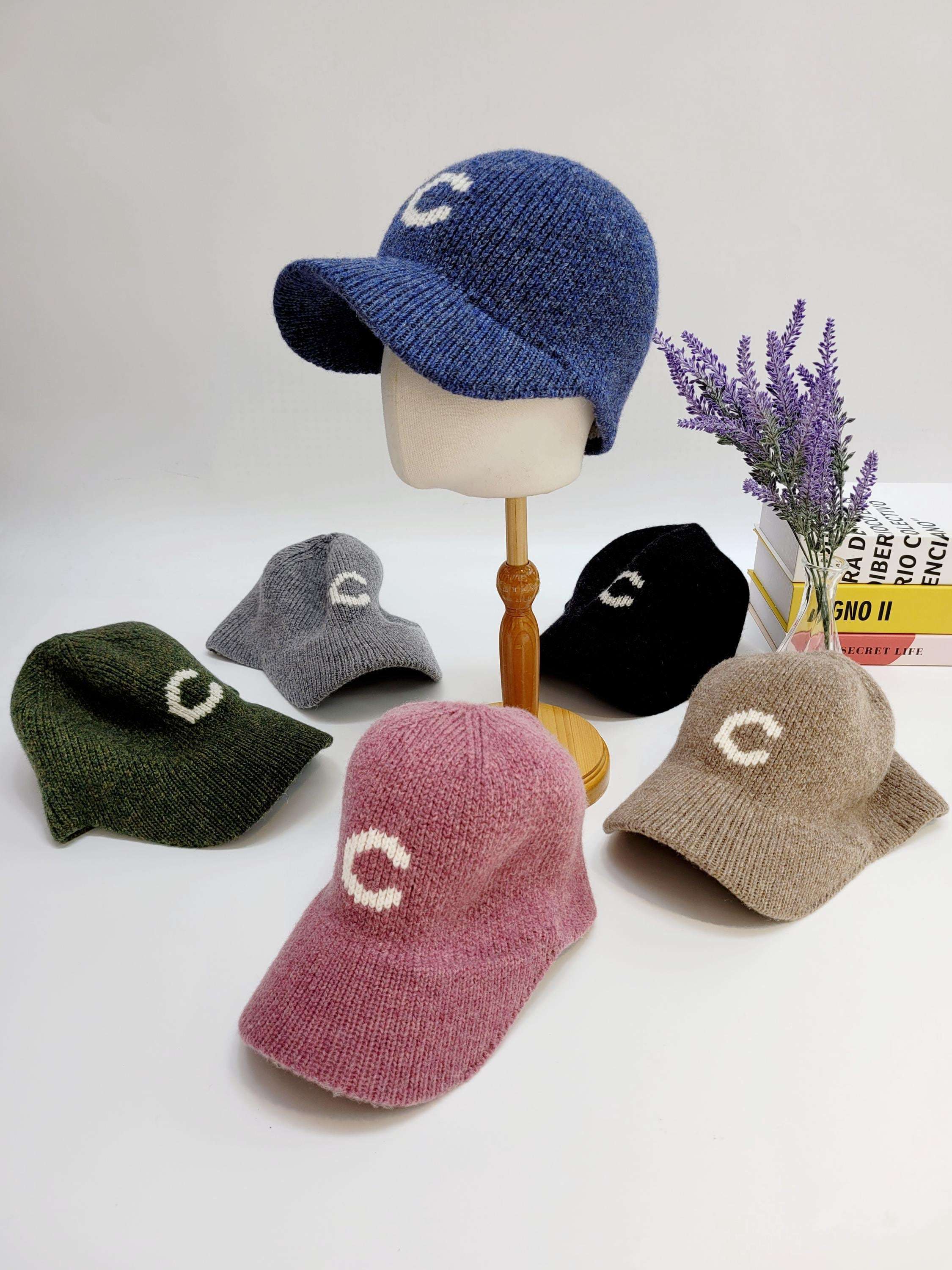 C-wool cap collection: knitted baseball caps in blue, gray, black, green, pink, and beige, each featuring a prominent "C" emblem.