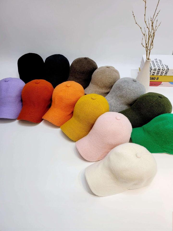 Assorted wool cap collection: black, brown, purple, orange, yellow, gray, green, pink, and white. Soft texture, perfect for stylish warmth.