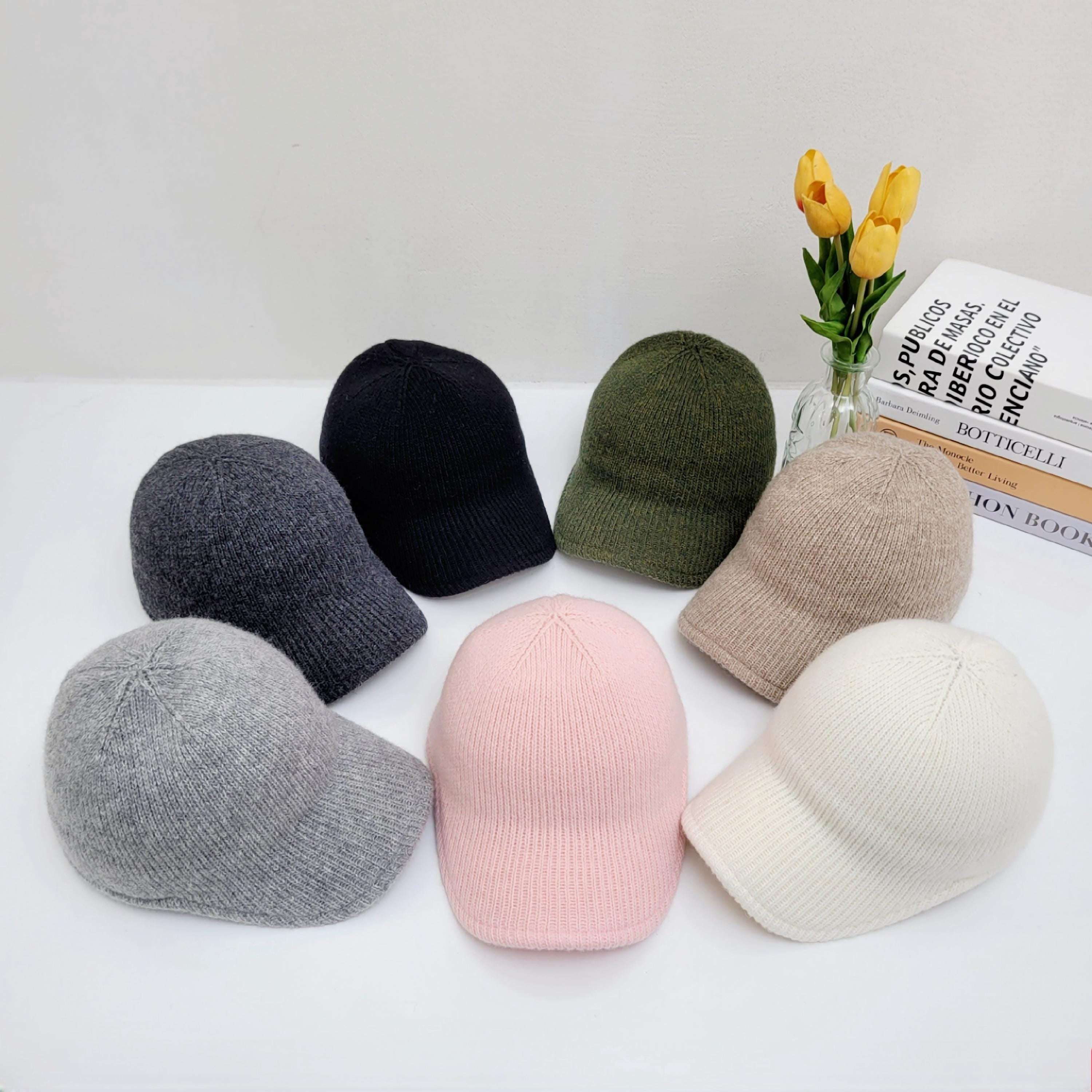 Seven ribbed cap hats in gray, black, olive green, beige, pink, and white, knitted texture visible