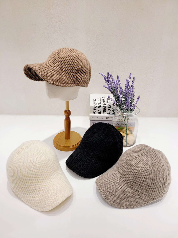 wool ribbed cap in beige, cream, black and taupe. Knitted caps displayed with lavender and books adding a lifestyle touch.