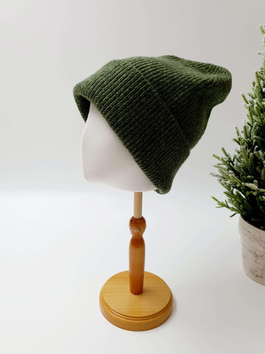 BEANIE THE WOOL: Green knit beanie hat on a mannequin head.