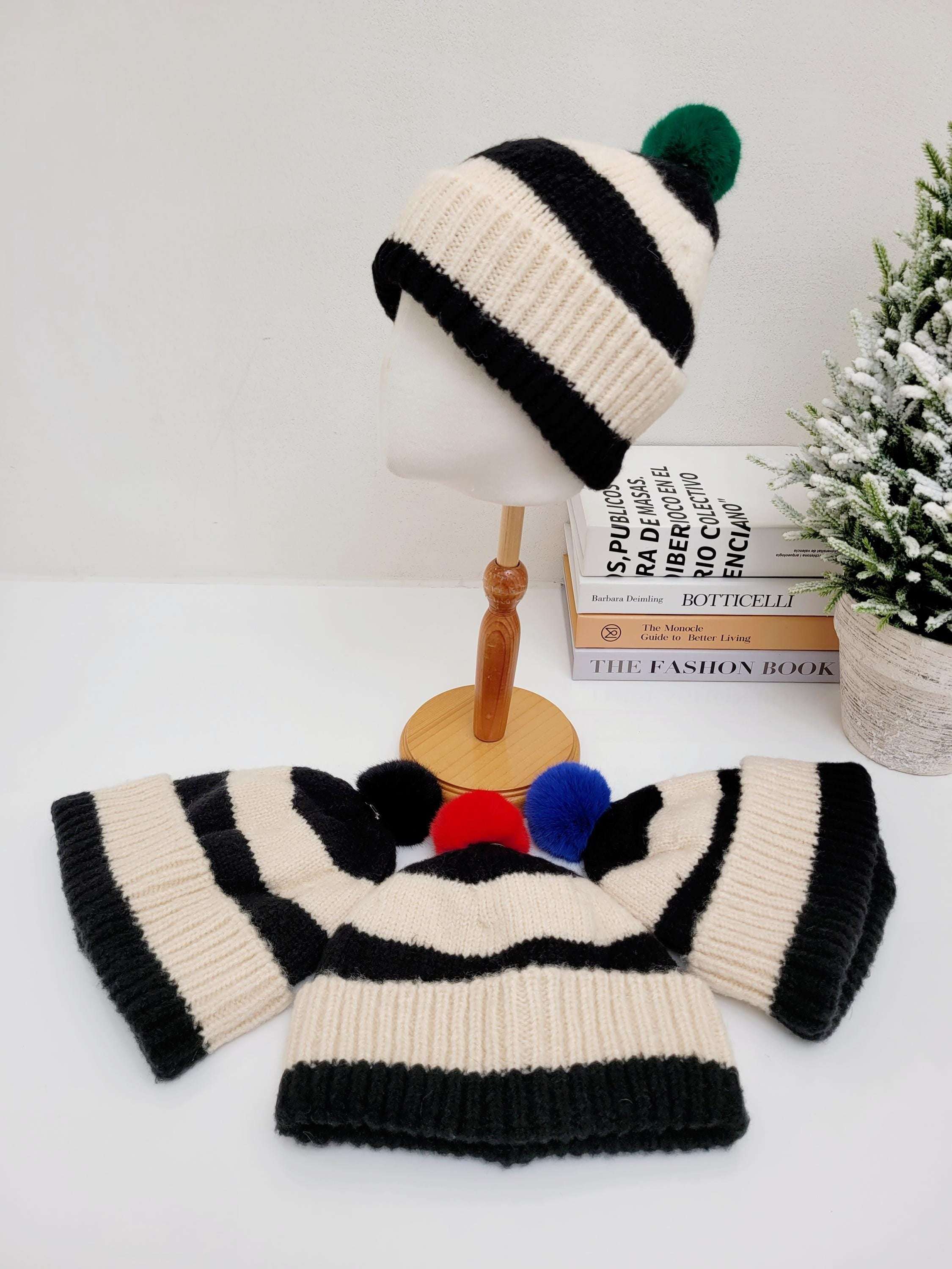 PARIS - B&W cream and black striped knit hat with a green pompom, paired with a matching scarf featuring multicolored pompoms.