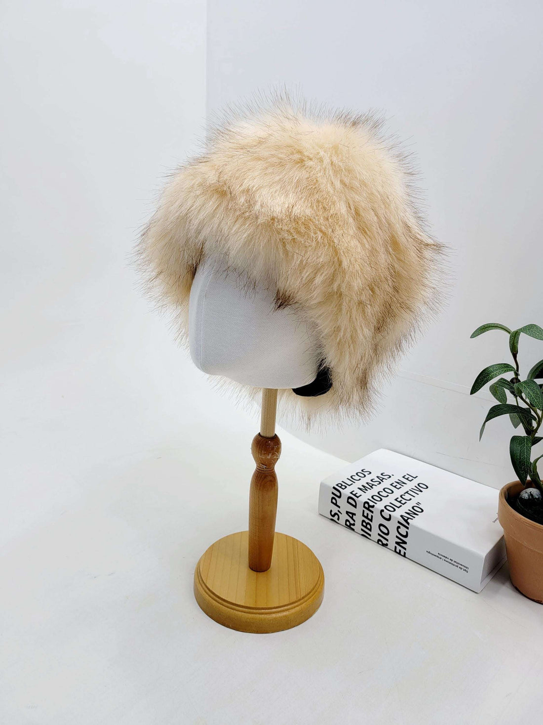 SONYA HAT FLUFFY: A fluffy, light brown fur hat displayed on a mannequin head, adding a touch of warmth and style.