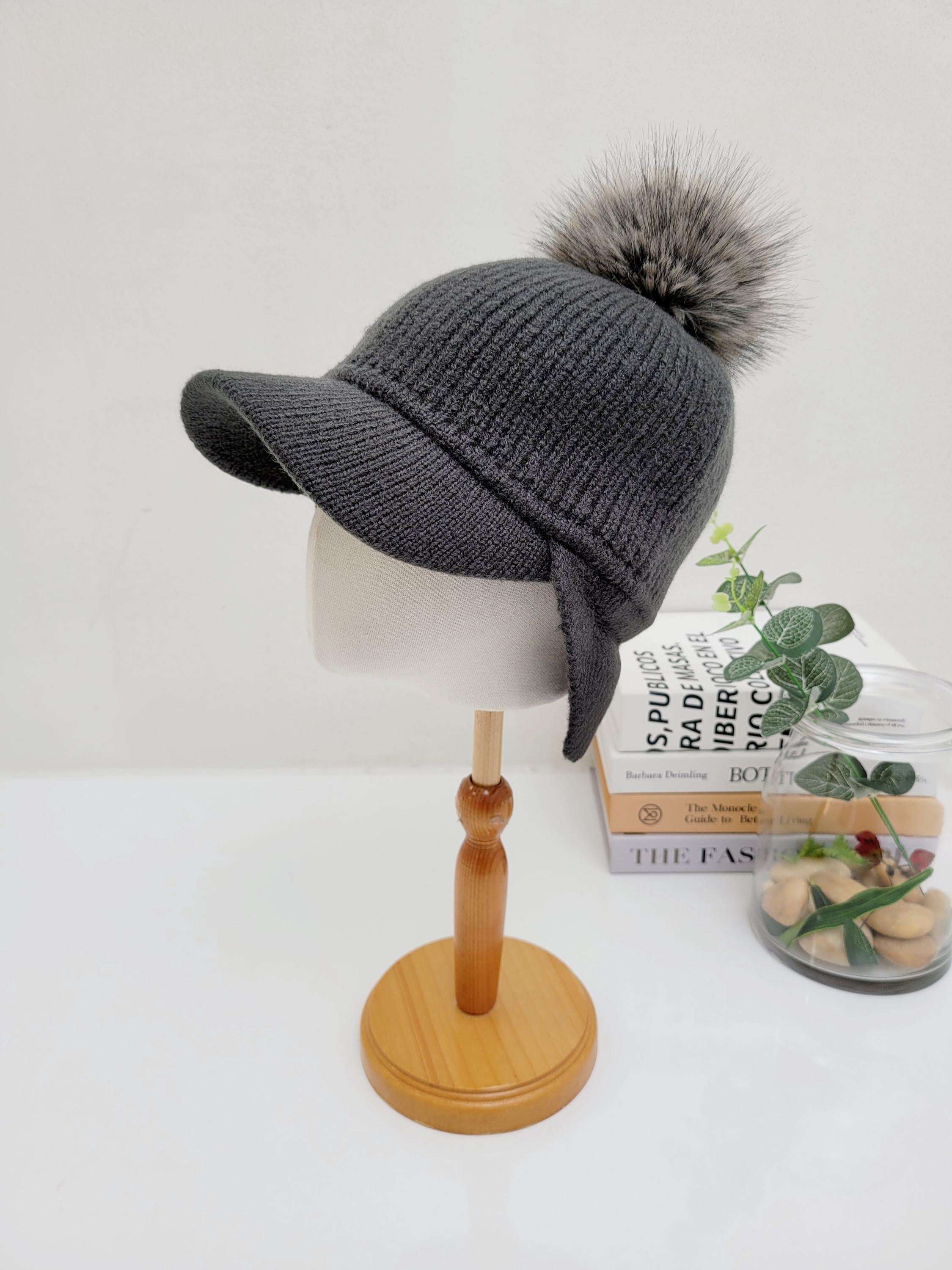 Gray ribbed cap - pom with ear flaps and a large faux fur pompom, displayed on a mannequin head.