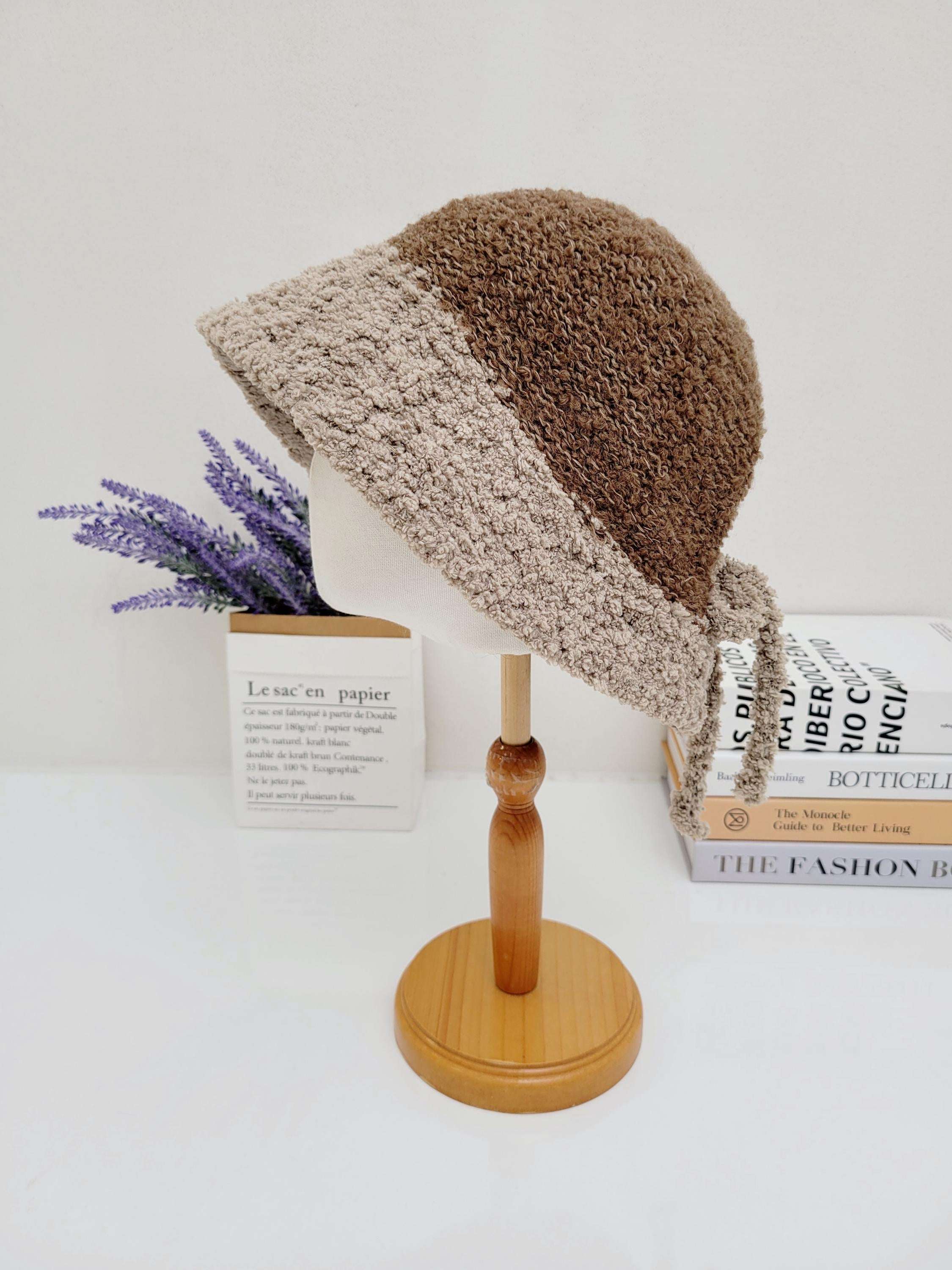 Brown and beige boho bucket - sherpa hat with a soft, textured feel, displayed on a wooden stand.