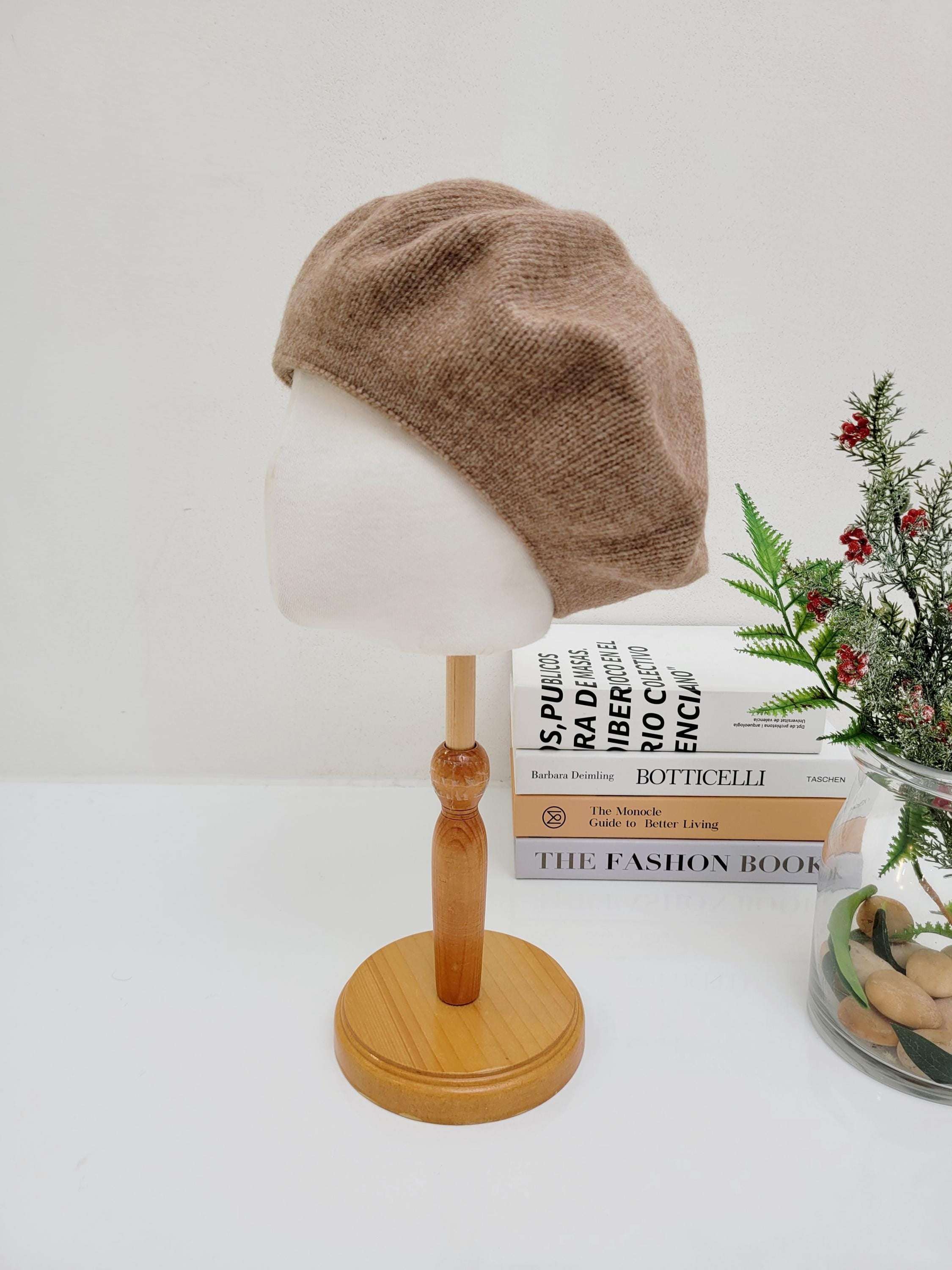 Light brown paris wool beret on a mannequin head. A stylish and classic accessory.