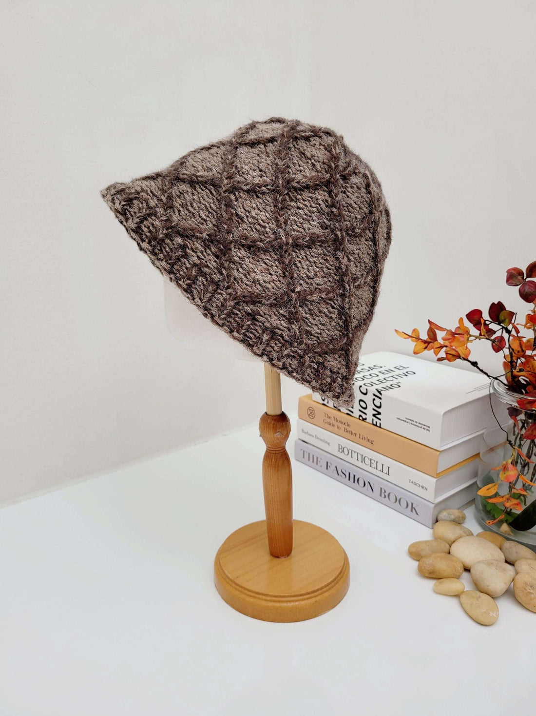 winter in the paris: Brown knit bucket hat with textured diamond pattern displayed on a wooden hat stand.