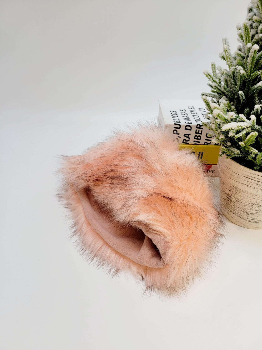Fluffy pink faux fur sonya hat fluffy, soft and warm. Perfect winter accessory displayed next to a small plant.