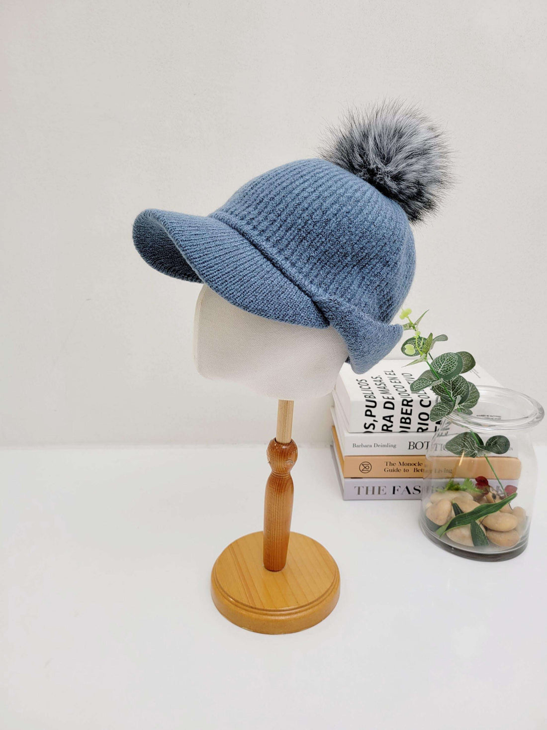 Blue ribbed cap - pom with brim and fluffy pom-pom, displayed on a mannequin head