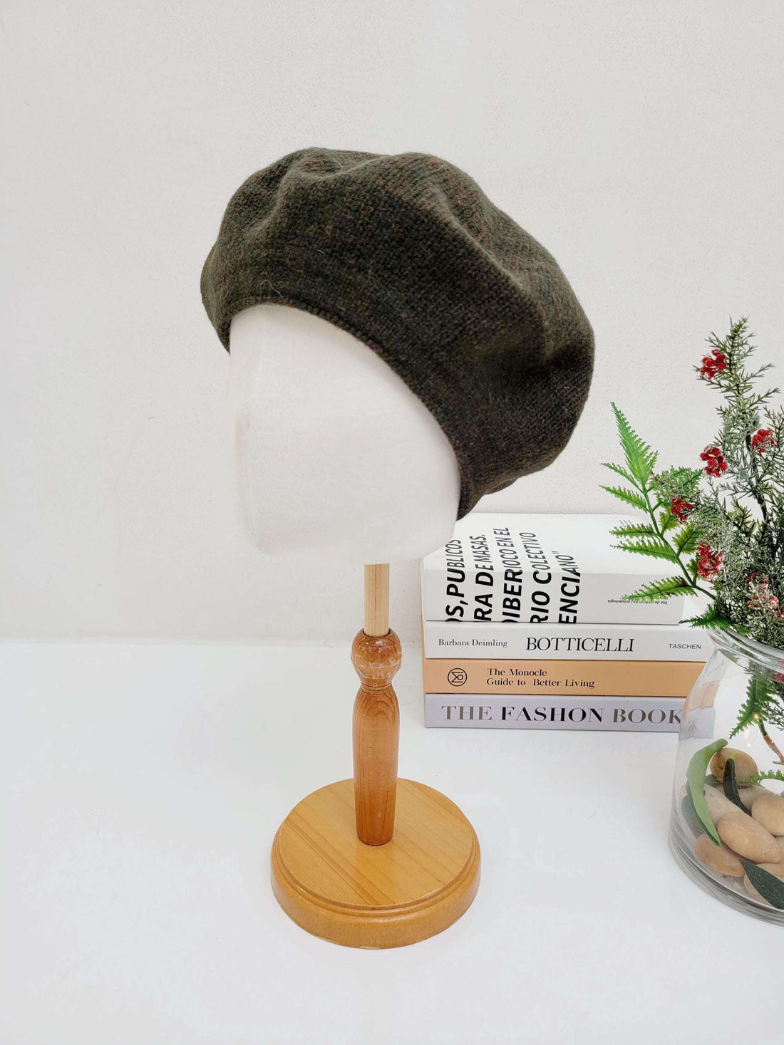 paris wool beret in olive green displayed on a mannequin head, classic and stylish headwear.
