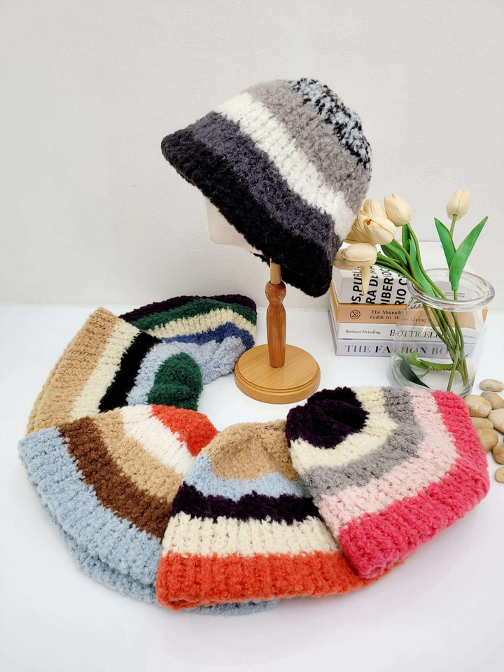 Assorted striped knit hats, including the tokyo beanie - stripe, displayed with diverse color palettes on a clean white surface, one presented on a wooden stand.