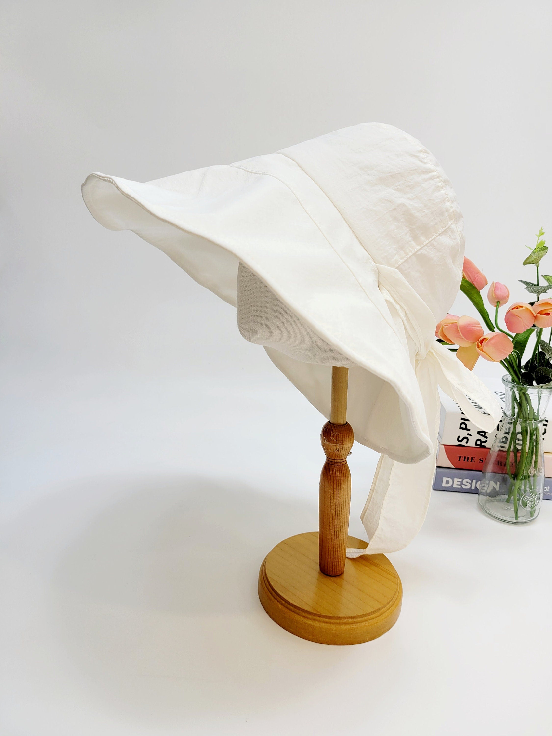 my fair lady white sun hat on a wooden stand, featuring a wide brim and tie detail, perfect for sun protection.