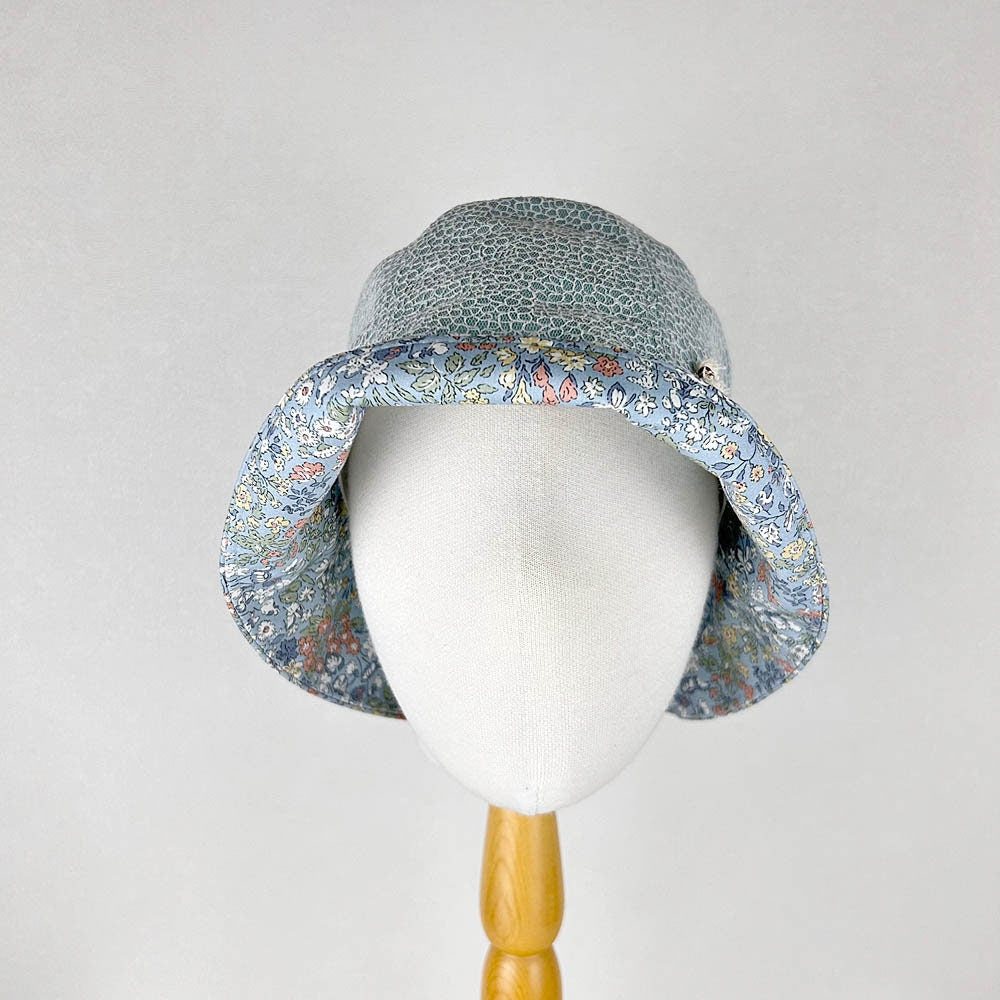 cotton viscose summer bucket hat with a blue floral print on the brim and a smaller, denser floral pattern on the crown.