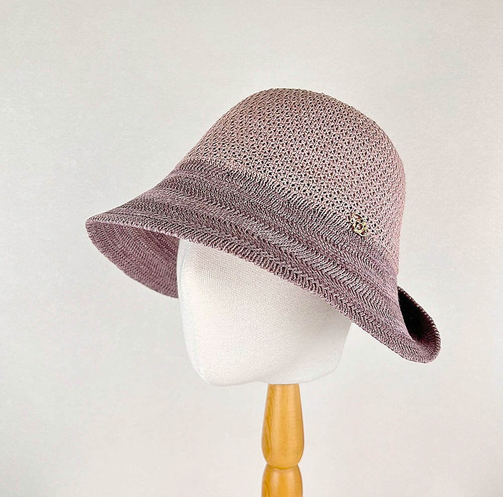 Victoria's summer hat: a stylish cloche-style sun hat in woven mauve and lavender with a decorative accent.