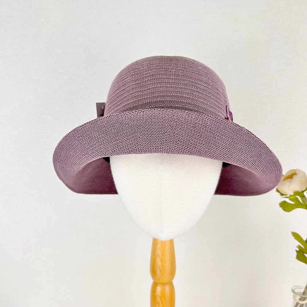 Purple woven sun hat with a wide brim, accented with a small bow. Ideal women's summer hat for sun protection.