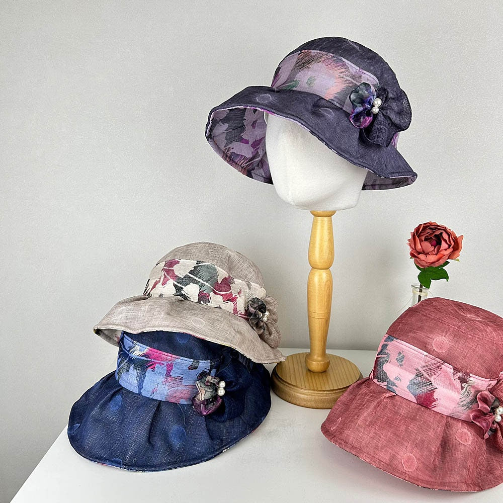 BOTANICAL hats: Collection of stylish sun hats with floral accents, displayed on a table.