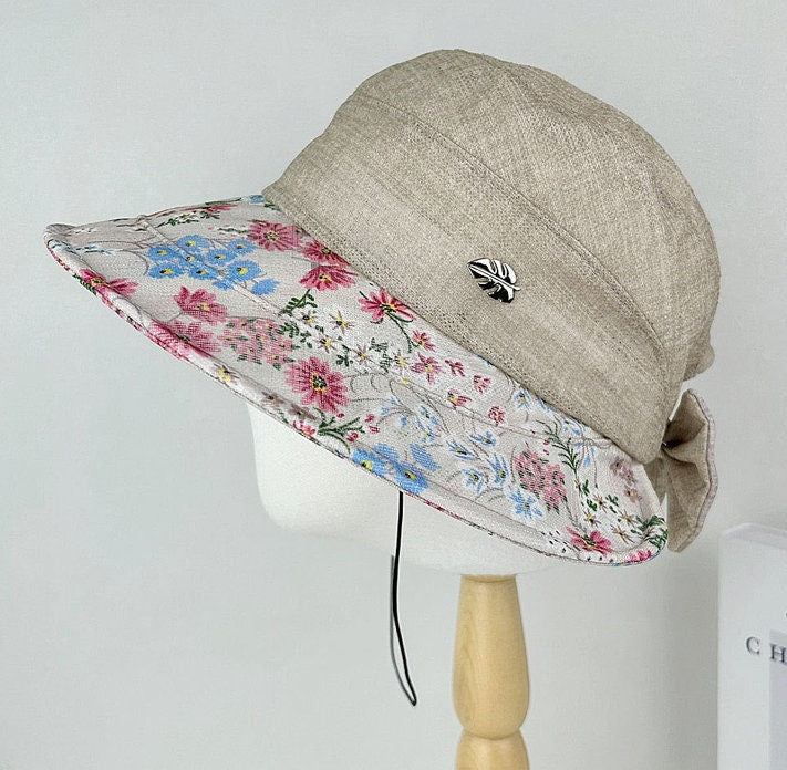 FLORAL BRIM SUMMER HAT: Beige sun hat with a colorful floral print brim, perfect for summer.