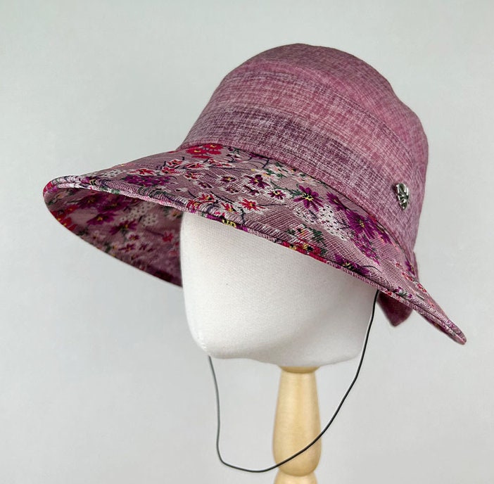 
floral brim summer hat: purple textured bucket hat with a wide floral print brim and adjustable chin strap.
