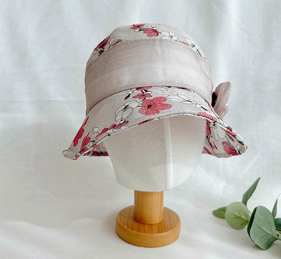 queens summer hat: floral print sun hat with a wide brim and sheer overlay, displayed on a mannequin head.