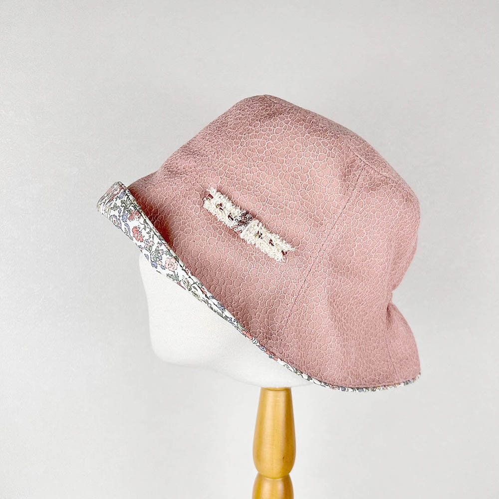Pink cotton viscose summer bucket hat with floral-print brim and decorative ribbon detail. A stylish sun hat.