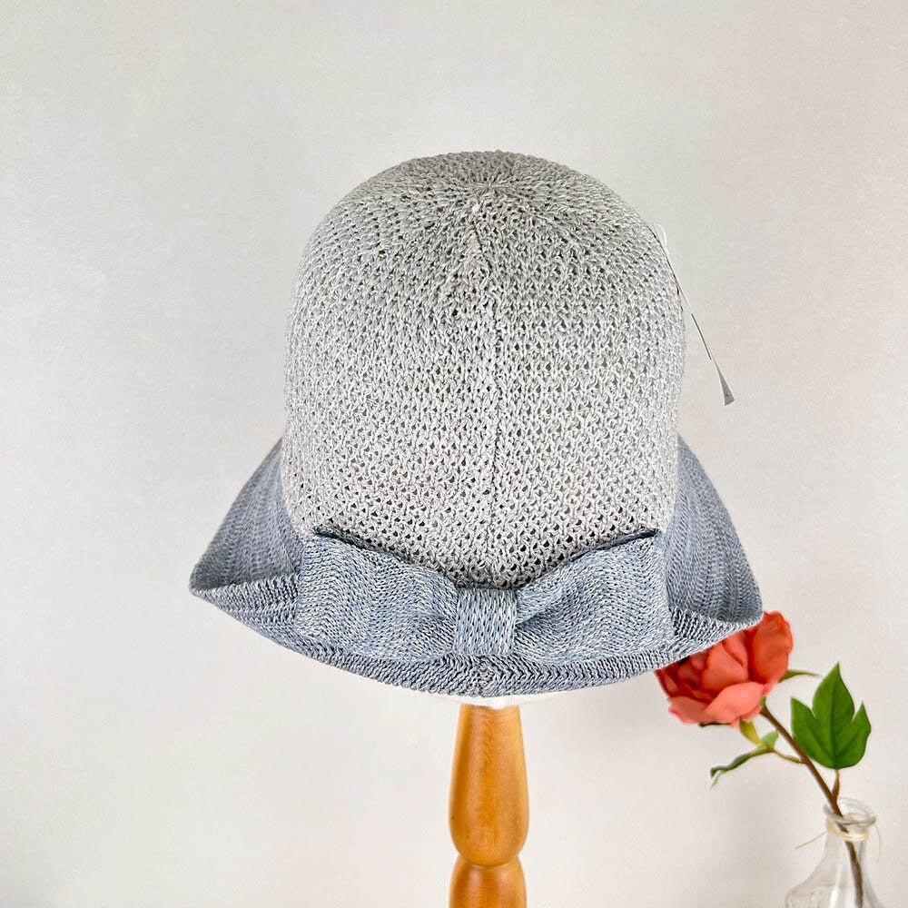 Grey knitted victoria's summer hat with a stylish blue bow accent, perfect for sun protection and adding a touch of elegance