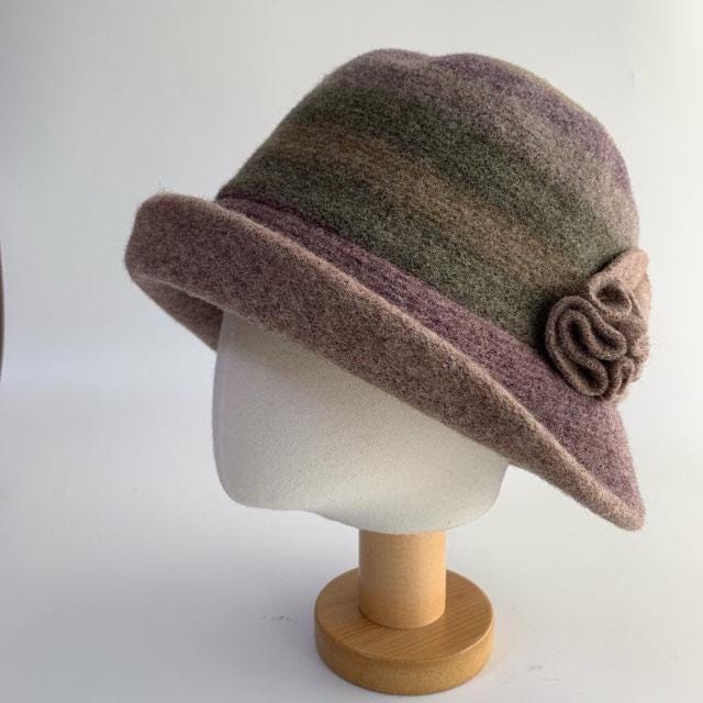 Mauve and olive green felt classic wool bucket hat with flower detail, displayed on a stand