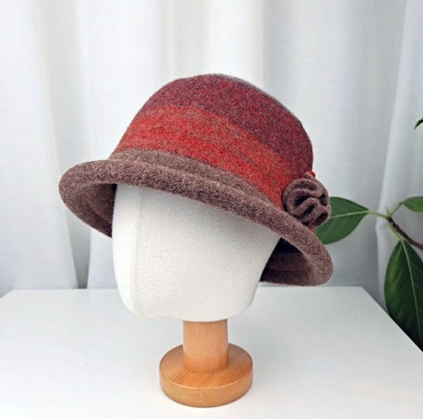 The kelly hat: a stylish felt cloche hat with a brown brim and a red-to-brown gradient crown, accented with a felt flower.