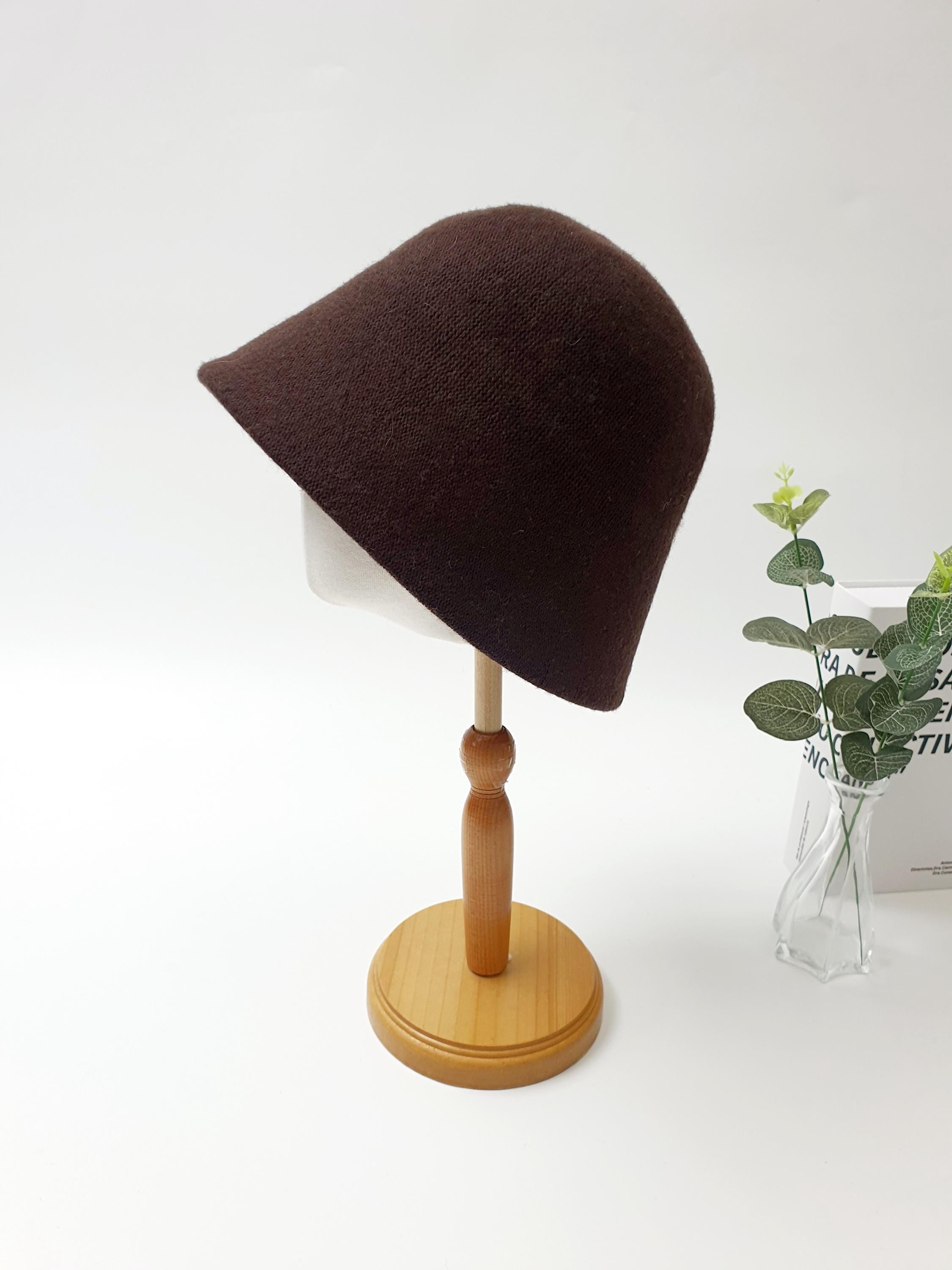 Brown fall'in winter bucket hat on a wooden stand. Soft, textured fabric and classic design.