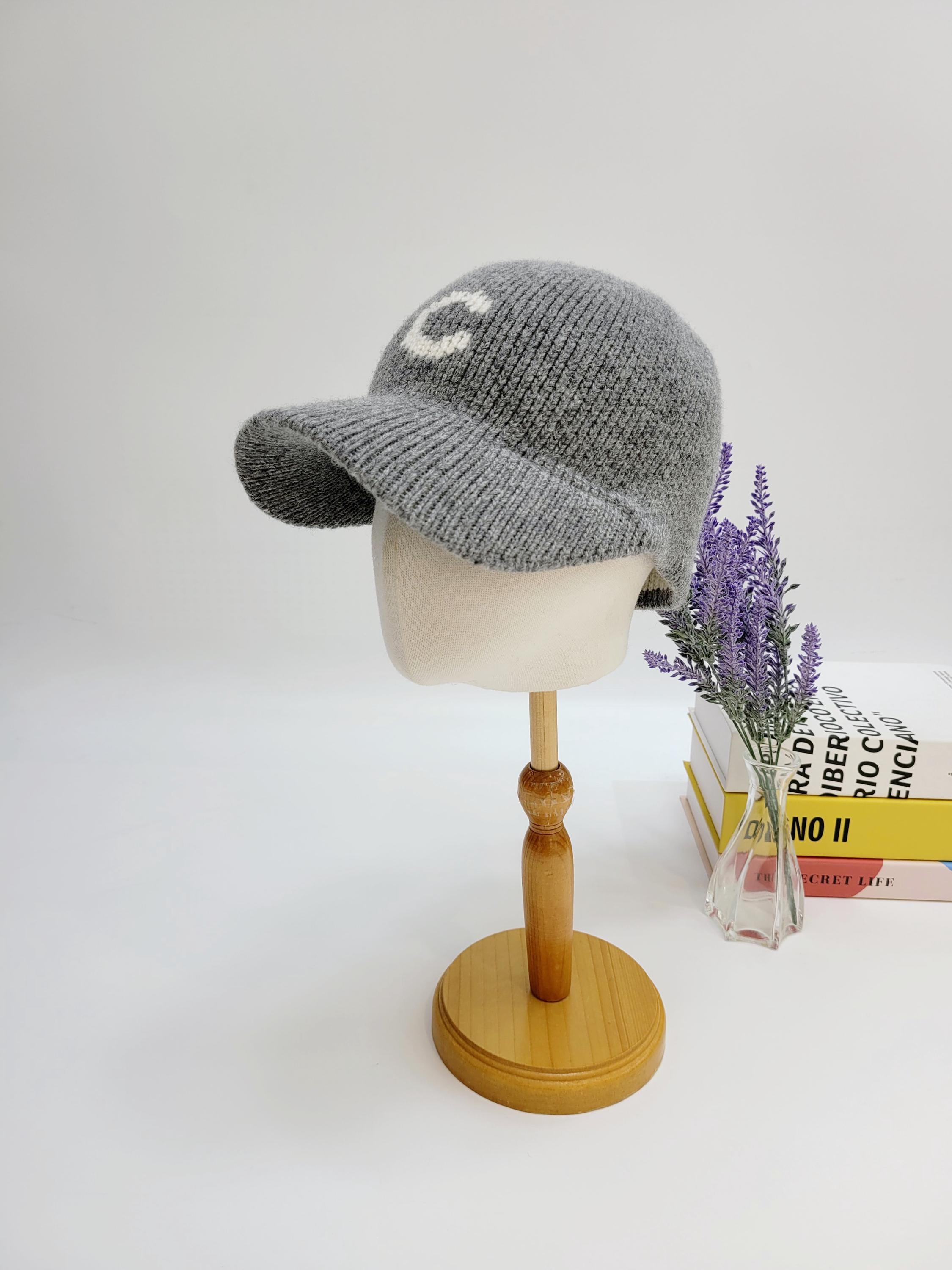 Grey knit c-wool cap with a prominent white "C" on the front, displayed on a mannequin head.