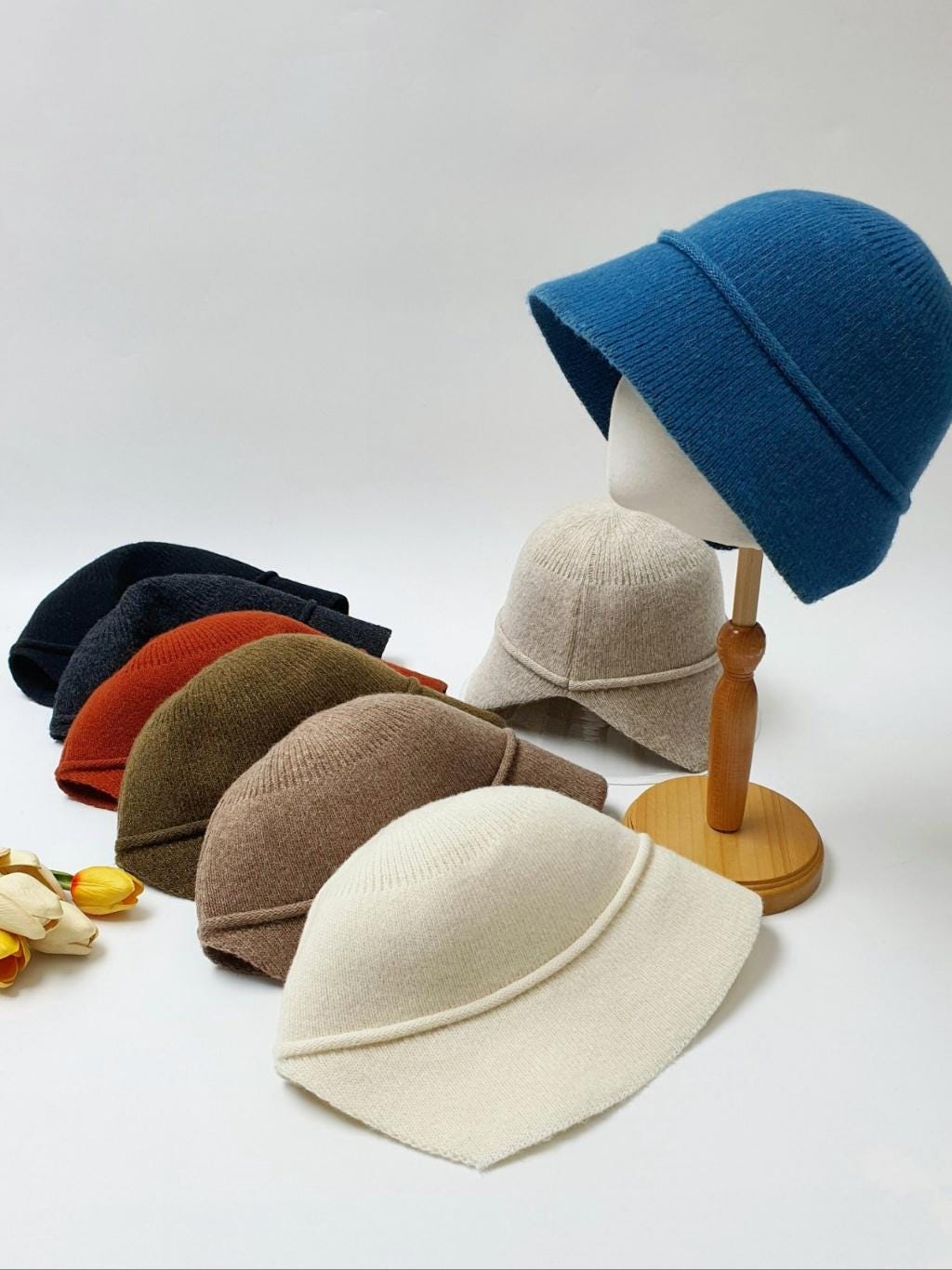blair knitted hats in a range of colors: blue, beige, black, orange, brown, and white. Soft, textured knit with a subtle brim detail.