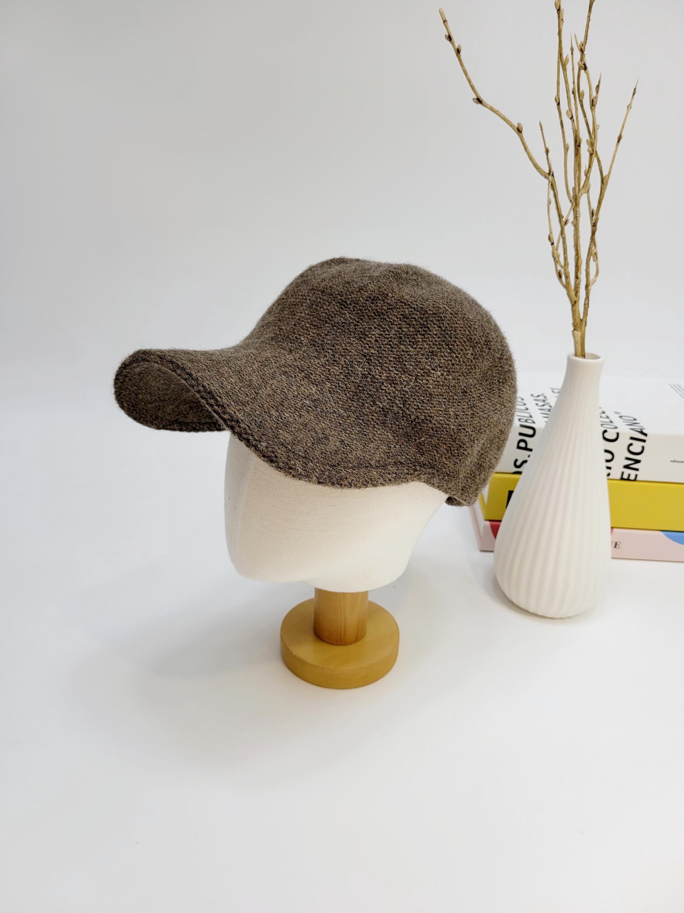 Brown wool cap on a mannequin head, showcasing its soft texture and classic design.