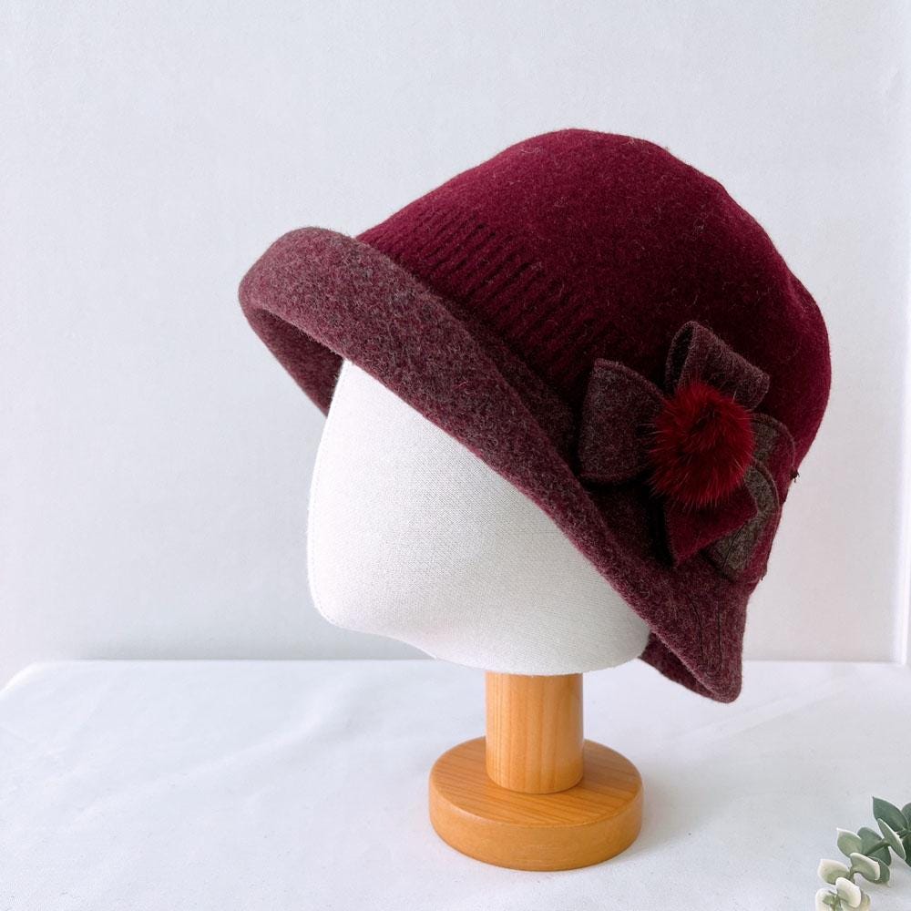 Burgundy vintage color wool bucket hat with a tonal flower accent and brim detail. 