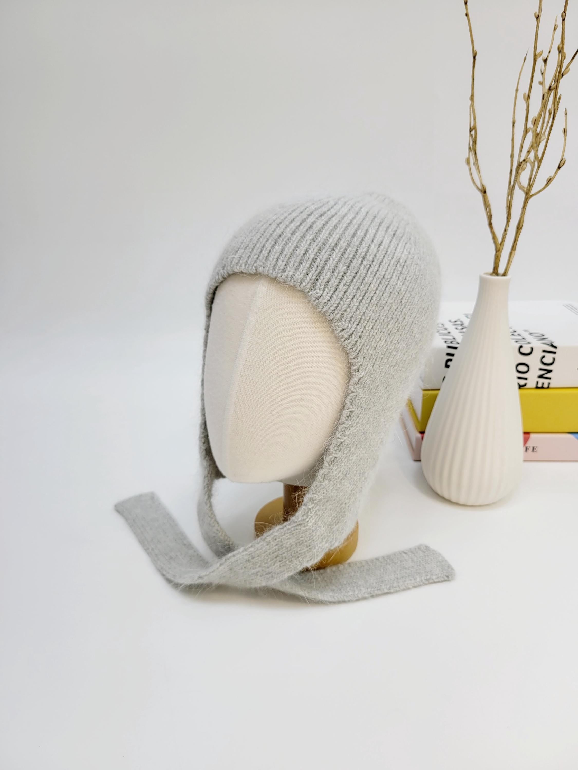 Grey wool balaclava hat with ear flaps and tie closure, shown on a mannequin head.