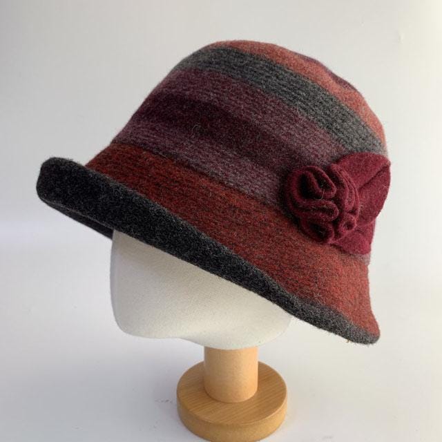 Classic wool bucket hat with burgundy, gray, and brown stripes. A burgundy flower accents this stylish cloche.