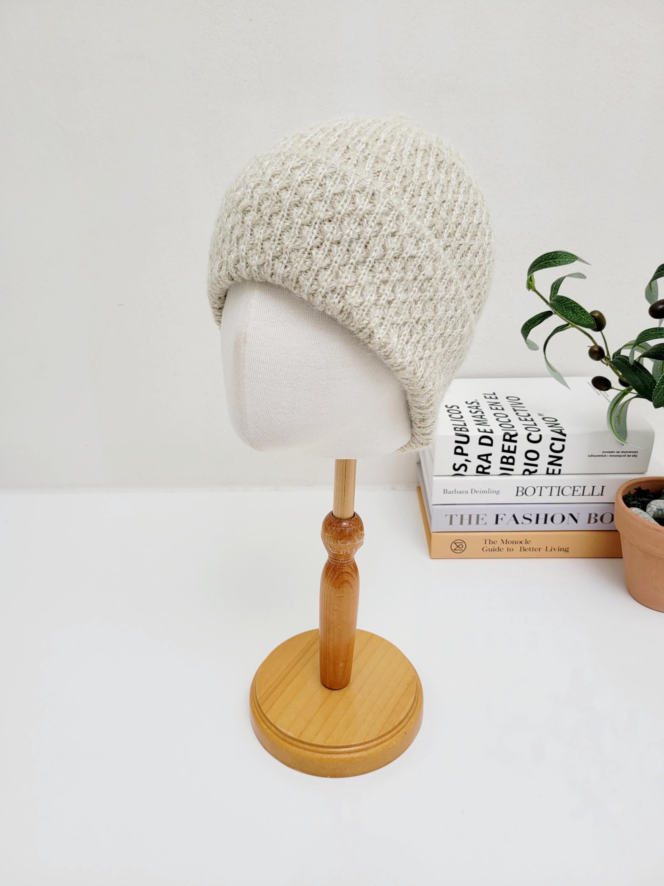 TAYLOR: Beige knit beanie with a subtle textured pattern, displayed on a mannequin head. Warm and stylish headwear.