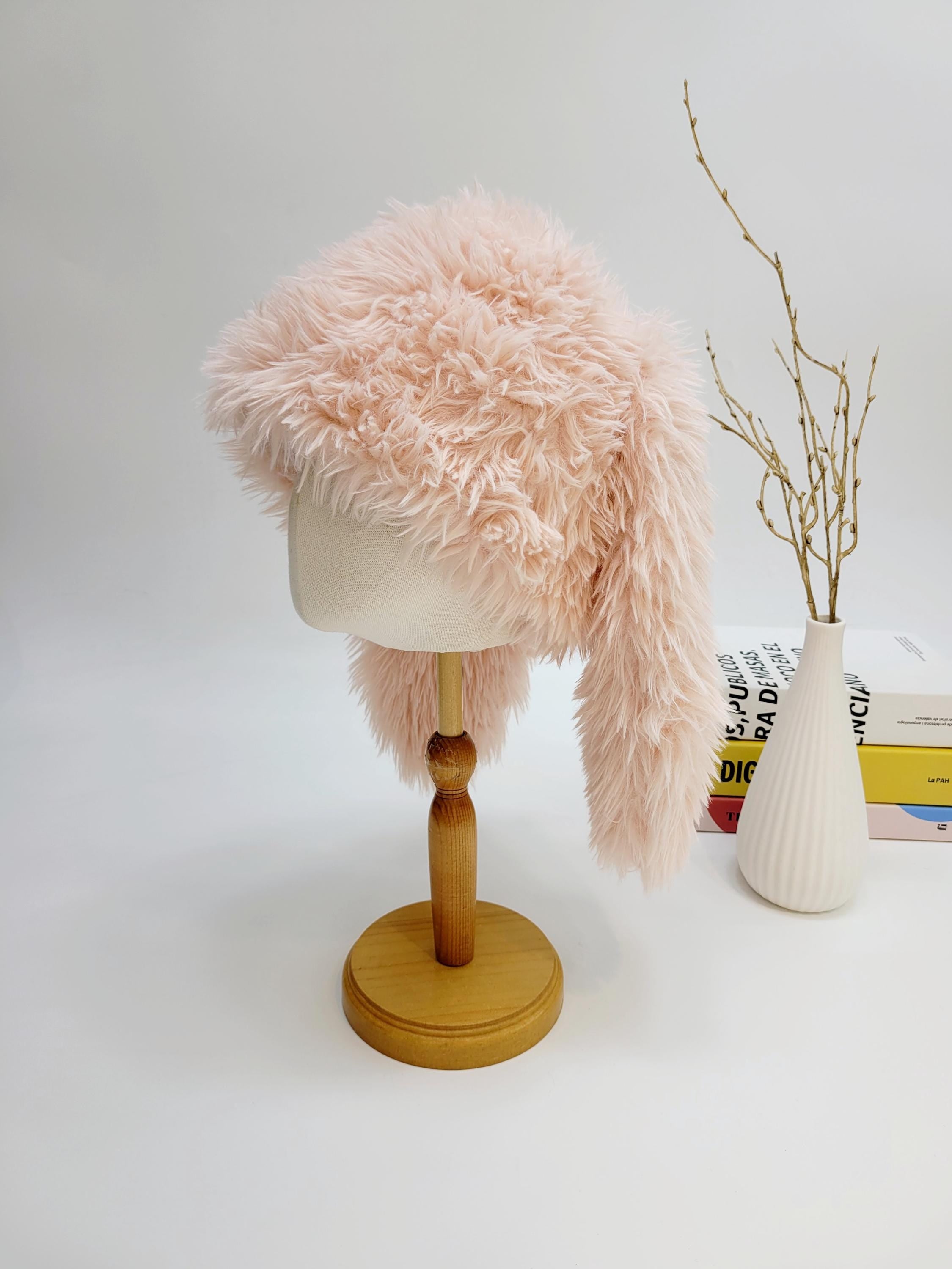 Soft pink "snow bunny" hat with shaggy faux fur, displayed on a mannequin head. A playful and warm winter accessory.