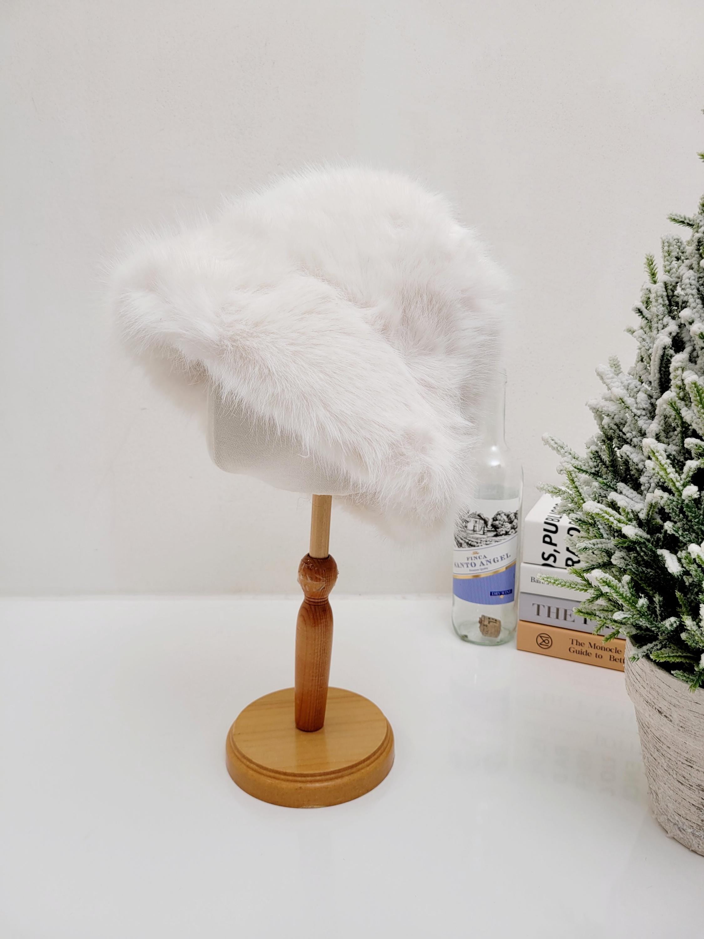 Fluffy white fake fur angelina winter spy hat displayed on a wooden stand