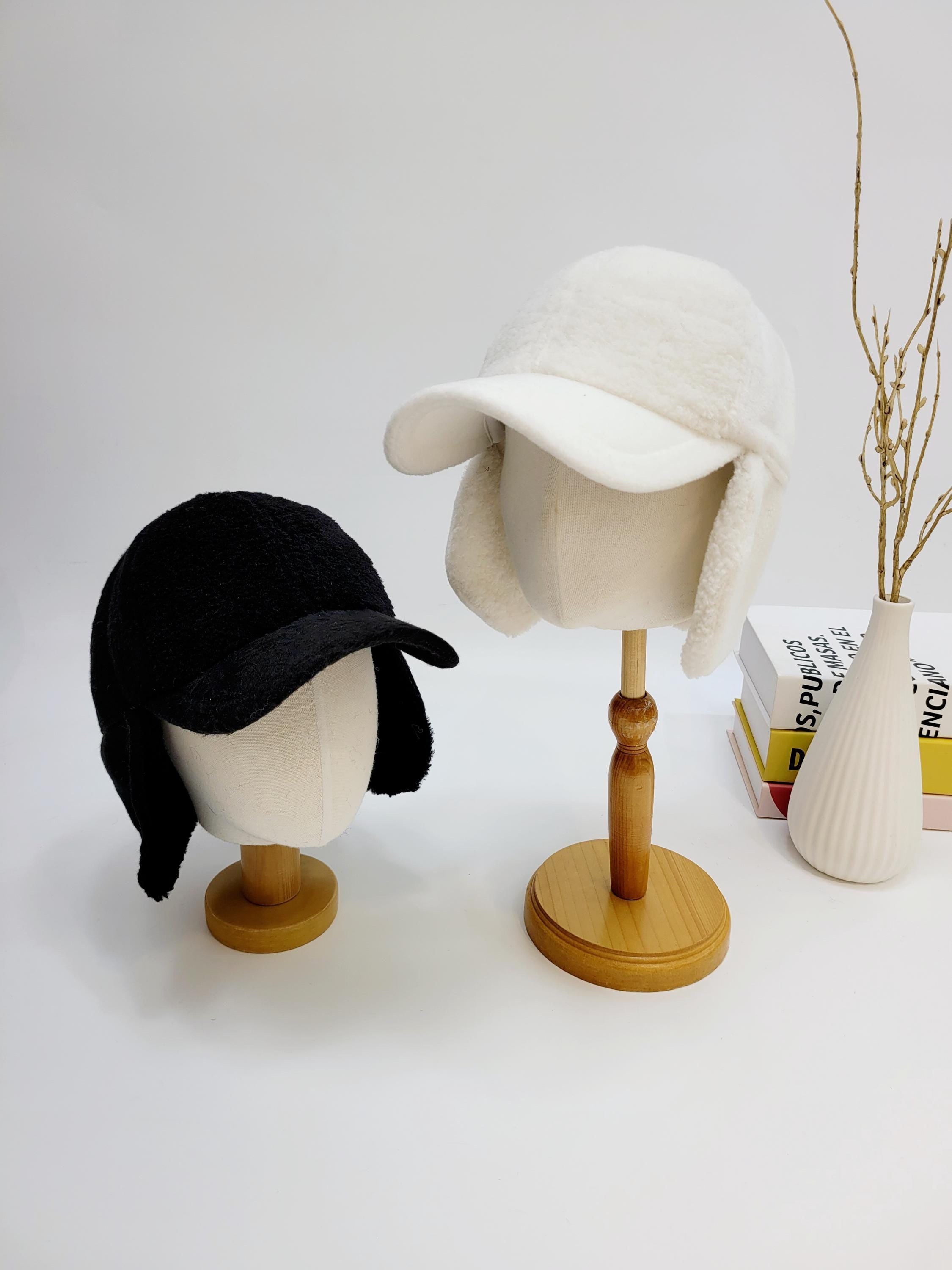 Black and white winter hats from jennifer on the street - winter, each with ear flaps and a short brim, displayed on mannequin heads.