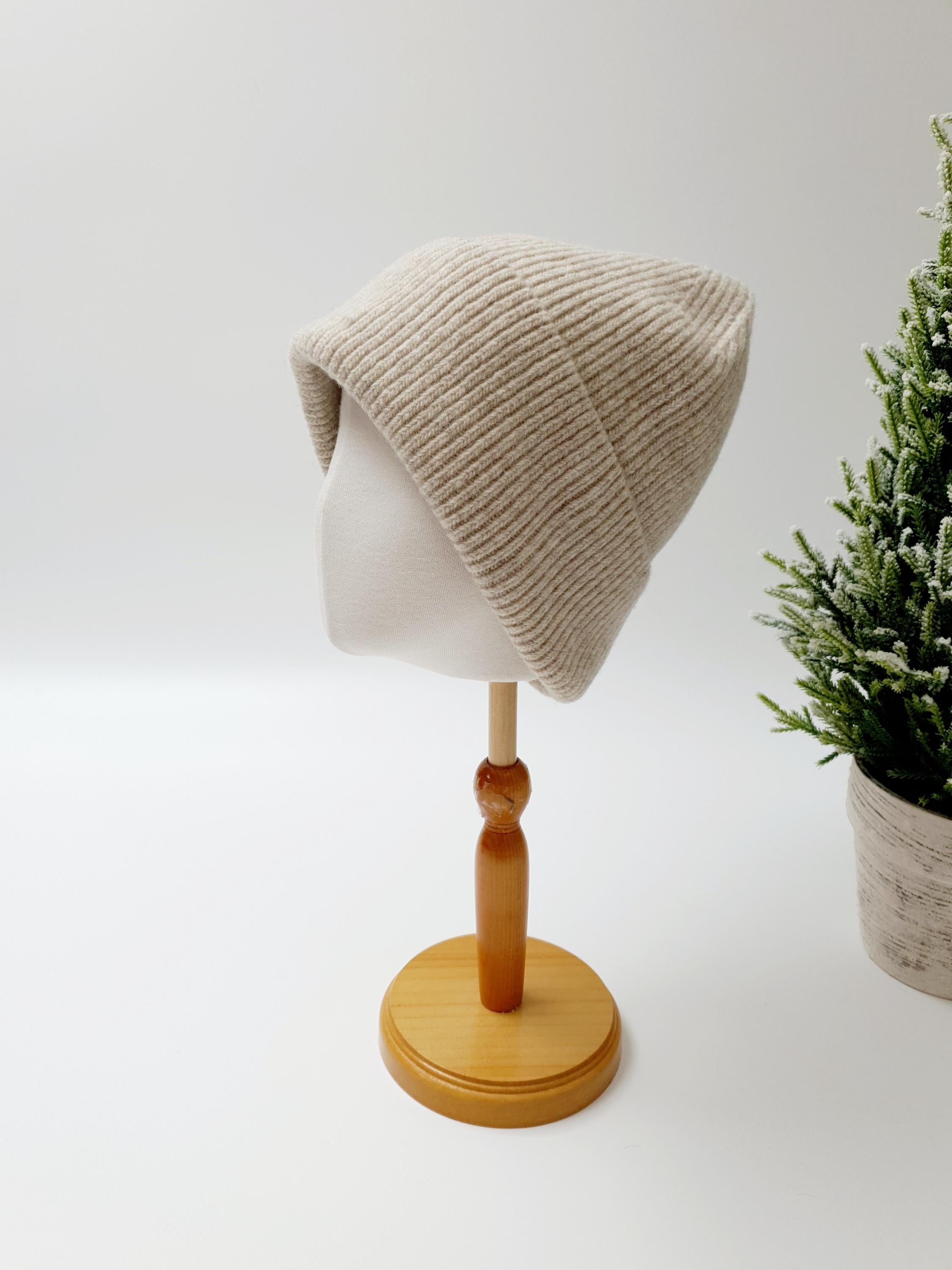 BEANIE THE WOOL: Beige ribbed knit beanie hat on mannequin head.