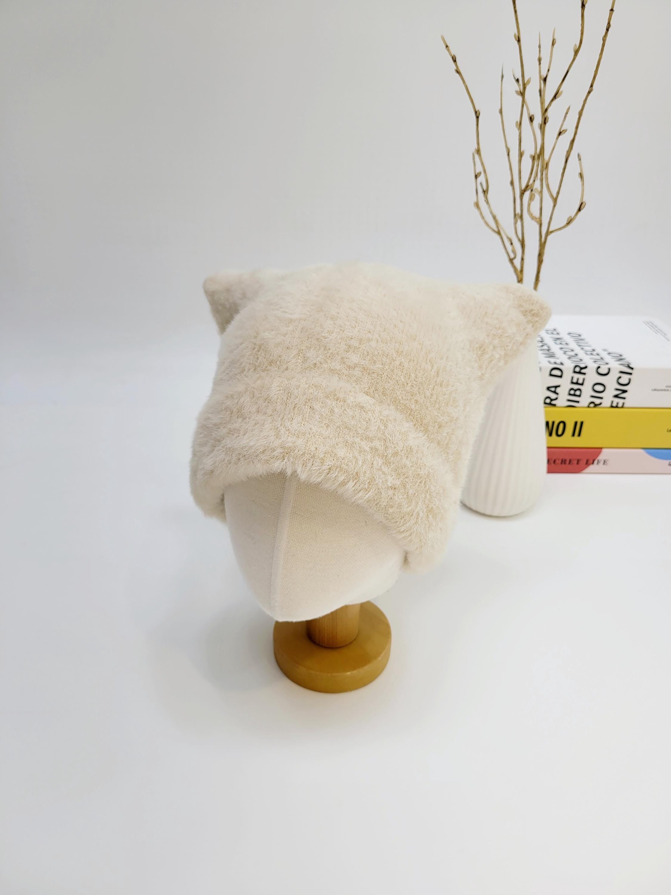ELF IN THE HAT: Creamy beige fuzzy winter hat with adorable cat ears, displayed on a mannequin head. A cute and cozy accessory.